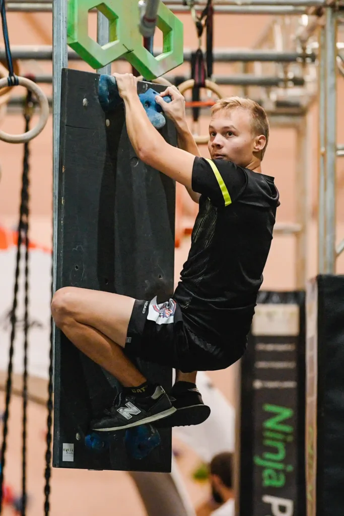 Mann überwindet einen Hindernisparcours in der Kletterarena