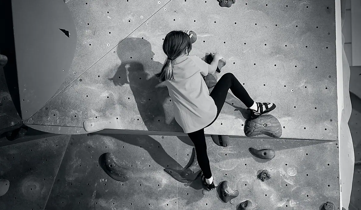 Mädchen klettert auf der Wand