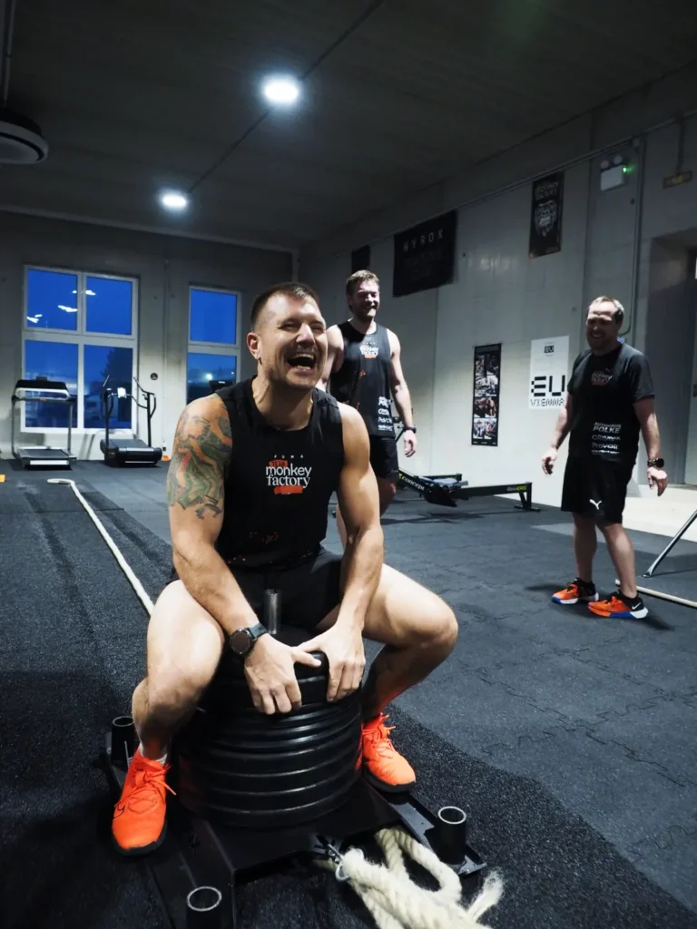 Ein Mann sitzt auf einem Crossfit-Trainingsgerät und lächelt