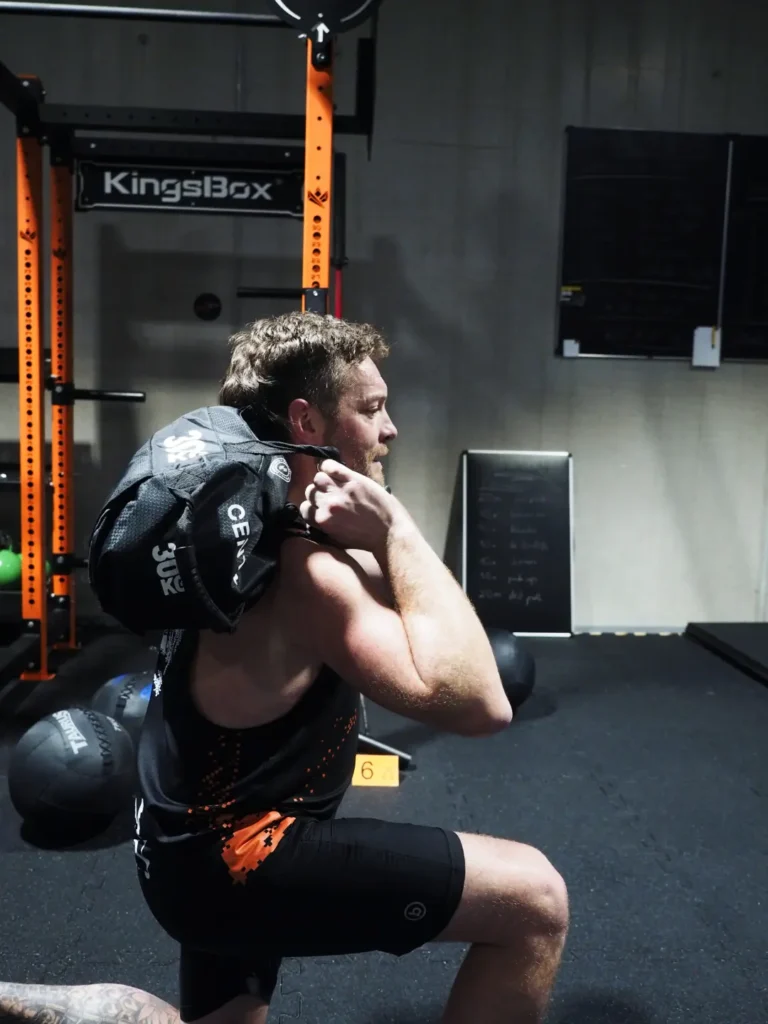 Mann trainiert Sandbag Lunges
