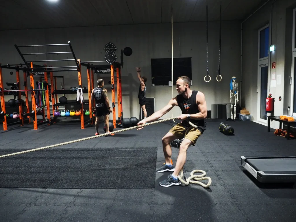 Mann trainiert Sled Pull mit Seil