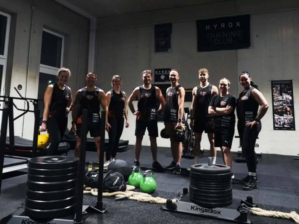 Gruppe von Menschen posiert lächelnd in einem Fitnessstudio